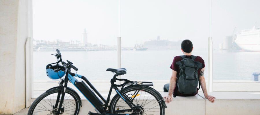 un homme assis à côté de son vélo électrique
